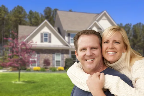 Casal feliz abraçando na frente da casa — Fotografia de Stock