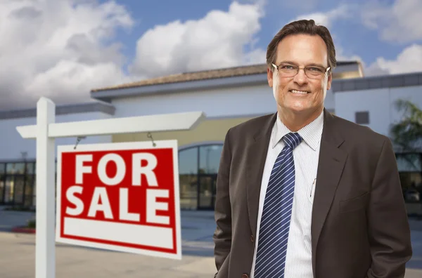 Geschäftsmann vor Bürogebäude und Verkaufsschild — Stockfoto