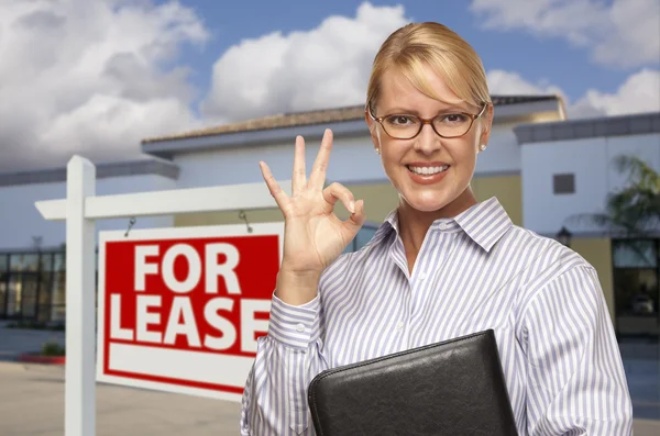 Geschäftsfrau vor Bürogebäude und für Pachtschild — Stockfoto