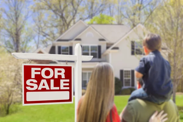 Familia frente a la venta de bienes raíces signo y casa —  Fotos de Stock