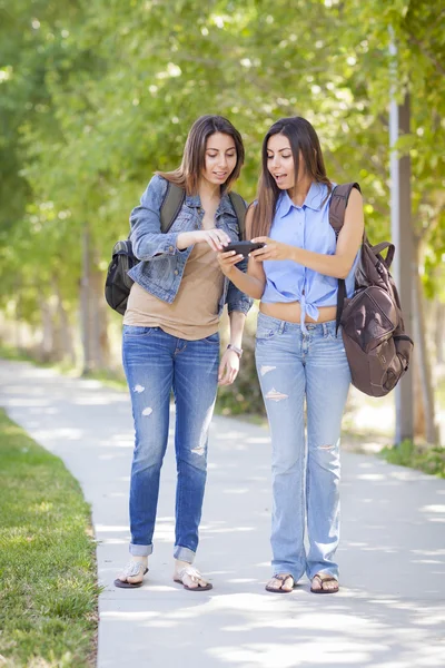 Hermanas gemelas de raza mixta de adultos jóvenes que comparten la experiencia del teléfono celular — Foto de Stock