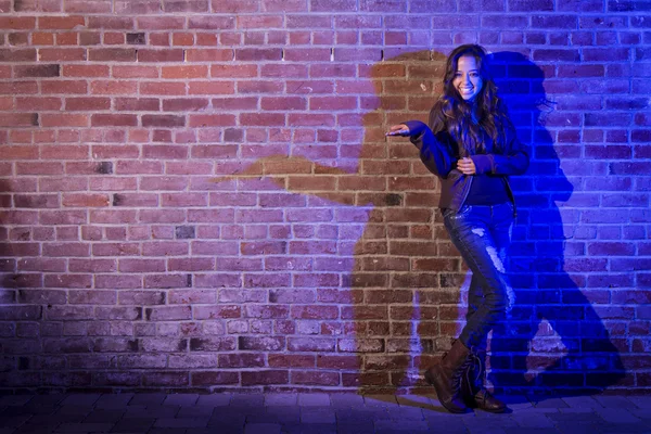 Misto razza donna tenendo il suo mano fuori contro mattone muro — Foto Stock