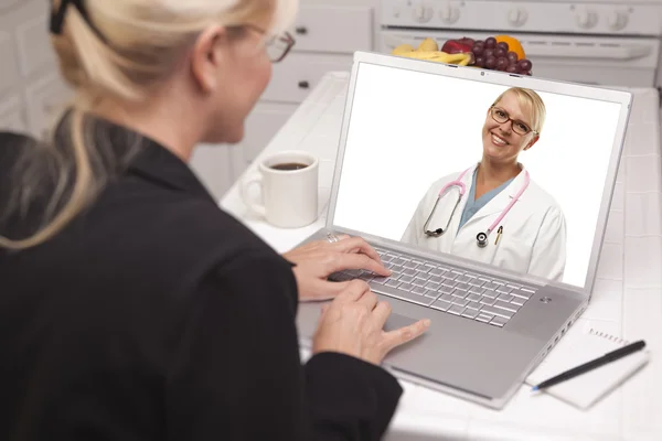 Mujer en la cocina usando el ordenador portátil - En línea con la enfermera o el médico —  Fotos de Stock