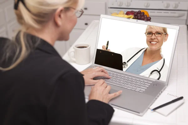 Donna in cucina utilizzando il computer portatile - Online con infermiera o medico — Foto Stock