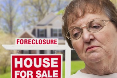 Depressed Senior Woman in Front of Foreclosure Real Estate Sign clipart