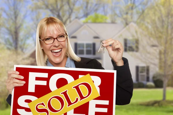 Frau mit verkauftem Schild und Schlüssel vor Haus — Stockfoto