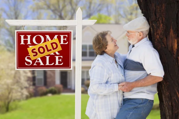 Immobilienschild mit Senioren-Paar vor Haus verkauft — Stockfoto