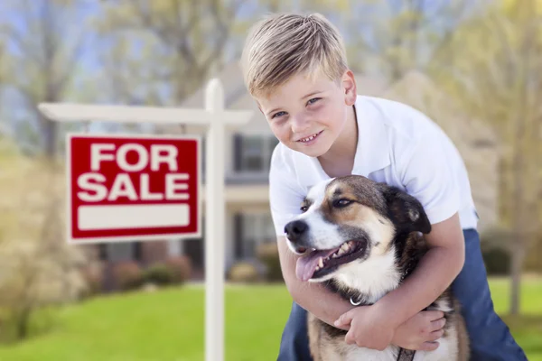 Kleiner Junge und sein Hund vor Verkaufsschild und Haus — Stockfoto