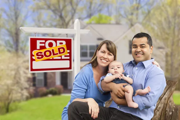 Satılan gayrimenkul işaret ve evin önünde genç ailesi — Stok fotoğraf