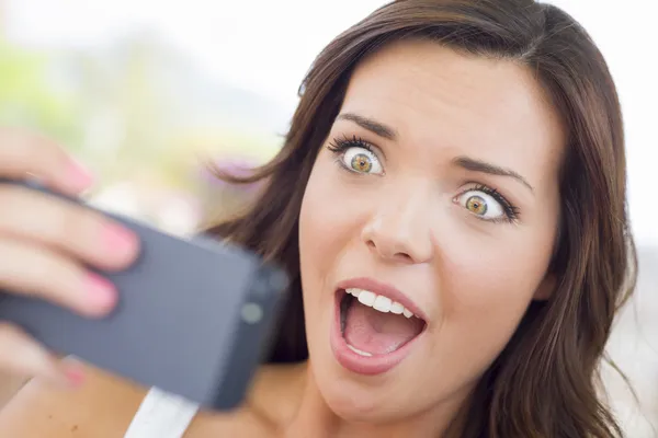 Shocked joven adulto hembra lectura celular al aire libre — Foto de Stock