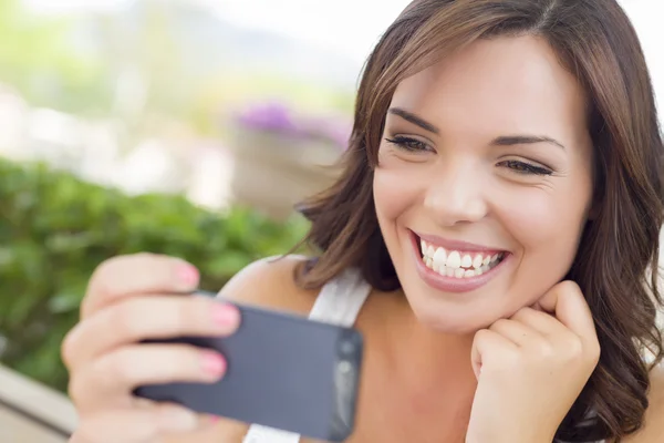 Mensajes de texto femeninos adultos jóvenes en el teléfono celular al aire libre — Foto de Stock