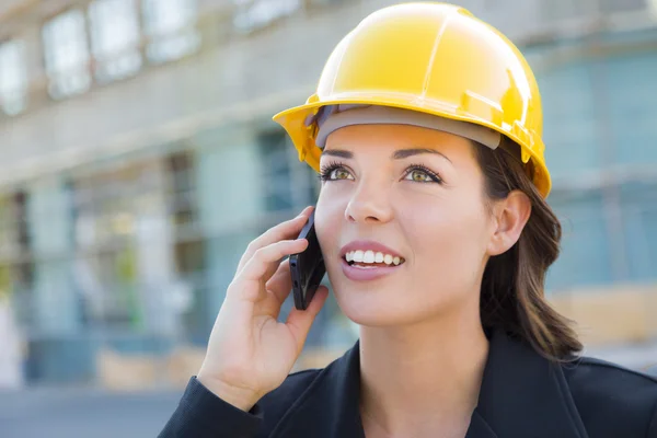 Jeune entrepreneure portant un casque de sécurité sur place à l'aide d'un téléphone — Photo