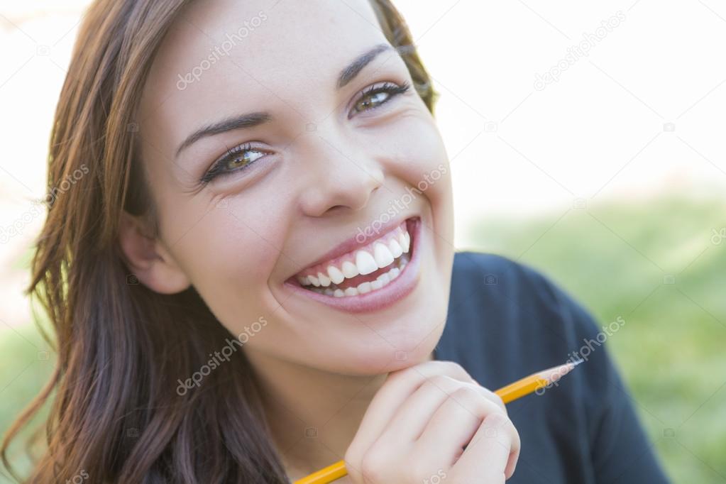 Portrait of Pretty Young Female Student with Pencil on Campus