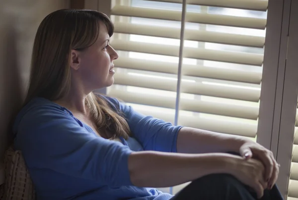 Pensive Woman Sitting Near Window Shades — Stock Photo, Image