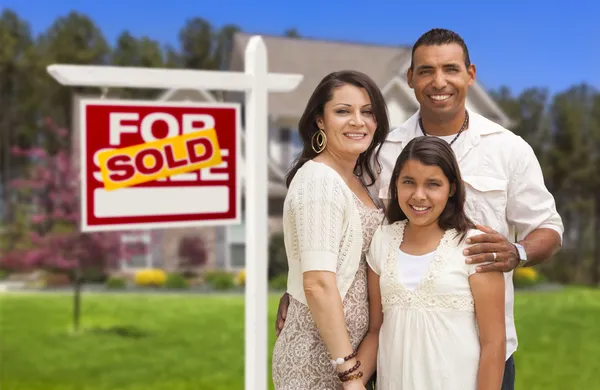 Familia hispana frente a su nuevo hogar y firma — Foto de Stock