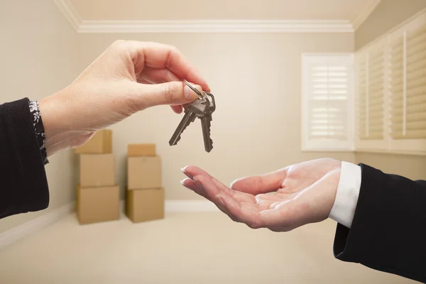 Donna che consegna le chiavi della casa dentro la stanza vuota dell'abbronzatura — Foto Stock