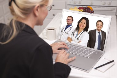 Mutfakta, dizüstü bilgisayar kullanarak kadın hemşire veya doktor ile online