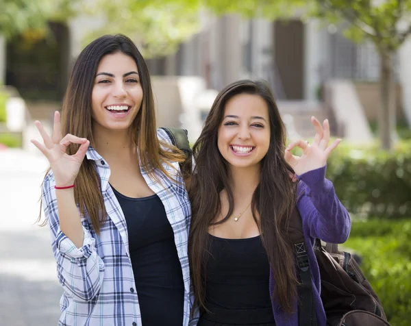 Gemengd ras vrouwelijke studenten op de campus van de school met goed teken — Stockfoto