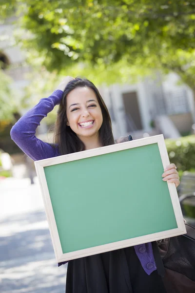 Взволнованная студентка смешанной расы держит чистую доску — стоковое фото
