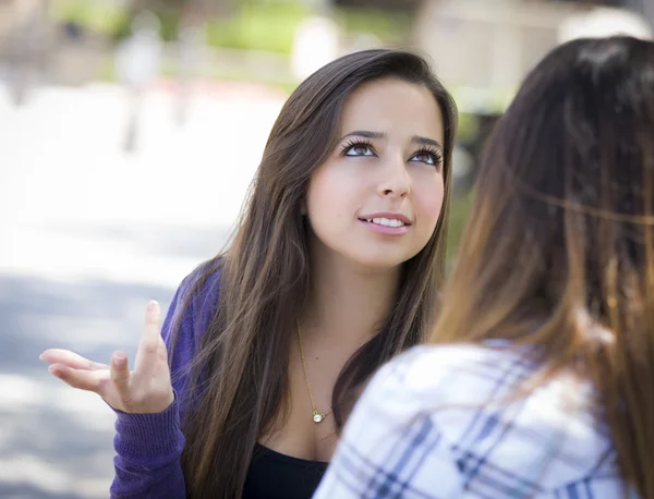 Expressieve jonge gemengd ras vrouw zitten en praten met meisje — Stockfoto