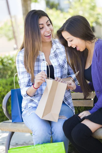 Fiatal felnőtt kevert nők látszó-ba a bevásárló szatyrok — Stock Fotó