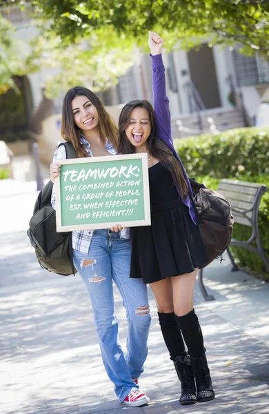 Estudiantes de raza mixta sosteniendo pizarra con trabajo en equipo y —  Fotos de Stock