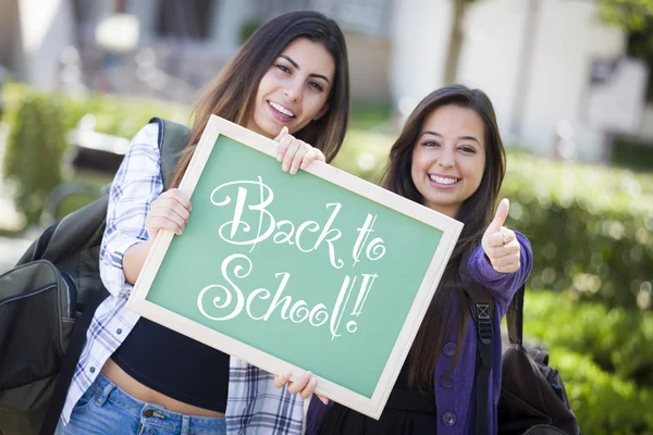 Vrouwelijke studenten gemengd ras holding schoolbord met terug naar schoo — Stockfoto