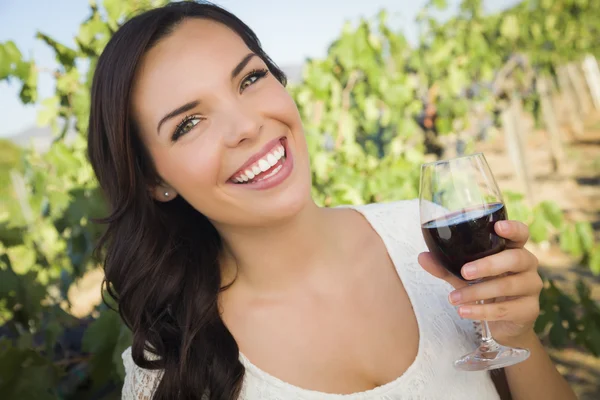 Jonge volwassen vrouw genieten van een glas wijn in de wijngaard — Stockfoto