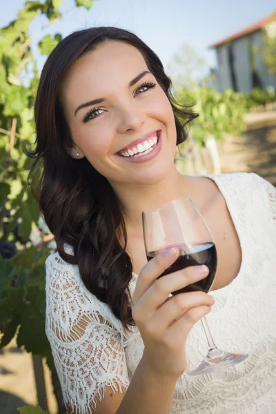 Νεαρή ενήλικη γυναίκα, απολαμβάνοντας ένα ποτήρι κρασί στον αμπελώνα — Φωτογραφία Αρχείου