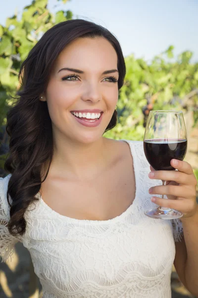 Jonge volwassen vrouw genieten van een glas wijn in de wijngaard — Stockfoto