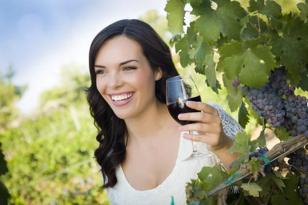 Jonge volwassen vrouw genieten van een glas wijn in de wijngaard — Stockfoto