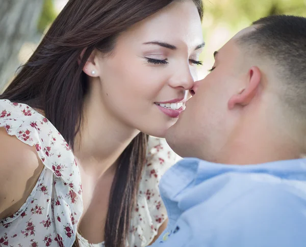Blandras romantiska par kyssar i parken — Stockfoto