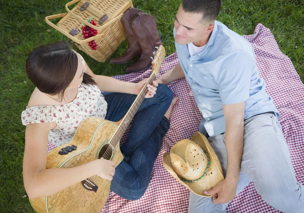 Pareja de carrera mixta en el parque tocando guitarra y cantando — Foto de Stock