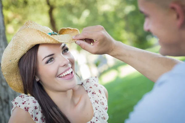 Pareja romántica de raza mixta con sombrero de vaquero coqueteando en el parque —  Fotos de Stock
