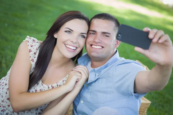 Casal de raça mista tomando auto retrato no parque — Fotografia de Stock