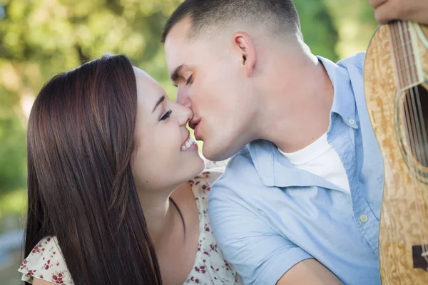 Portrait de couple mixte avec guitare dans le parc — Photo