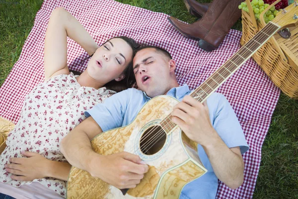 Casal de corrida mista no parque tocando guitarra e canto — Fotografia de Stock