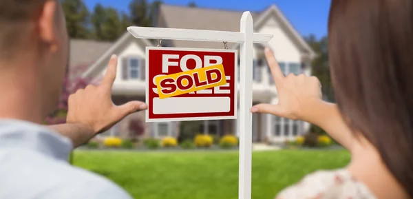 Vendido para venda sinal, casa e militar casal emoldurando as mãos — Fotografia de Stock