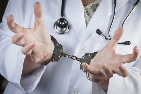 Врач или медсестра в наручниках в лабораторном халате и стетоскопе — стоковое фото