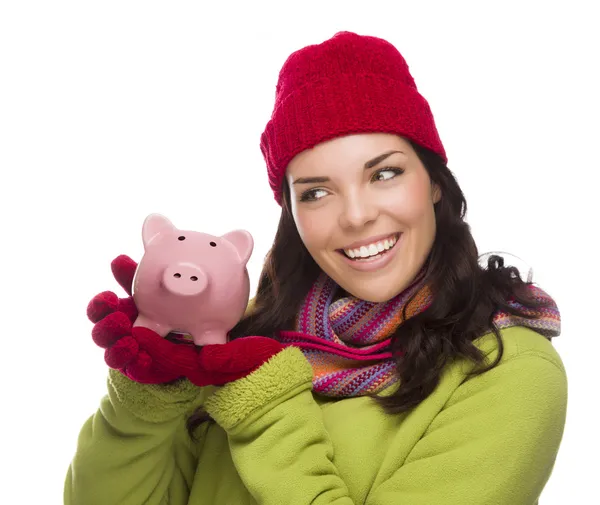 Smíšené rasy žena nosí zimní čepice drží prasátko na bílém pozadí — Stock fotografie