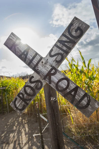 Ancien panneau de passage à niveau de chemin de fer de campagne près d'un champ de maïs — Photo