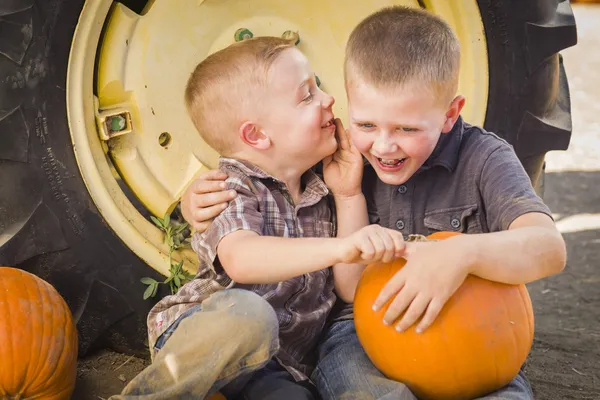 Two Boys Sitting Against Tractor Tire Holding Pumpkins Whisperin — Stock Photo, Image