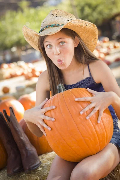 Preteen ragazza holding un grande zucca a il zucca patc — Foto Stock