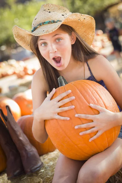 Chica preadolescente sosteniendo una calabaza grande en el Pumpkin Patc — Foto de Stock