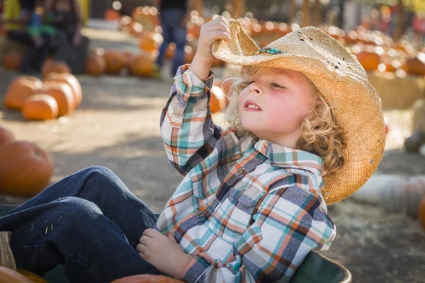 Kleine jongen in cowboy hoed op pompoen patch — Stockfoto