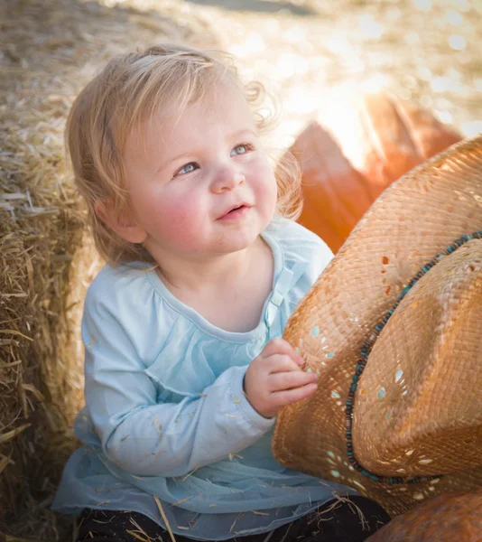 Schattige babymeisje met cowboy hoed op de pompoen patc — Stockfoto