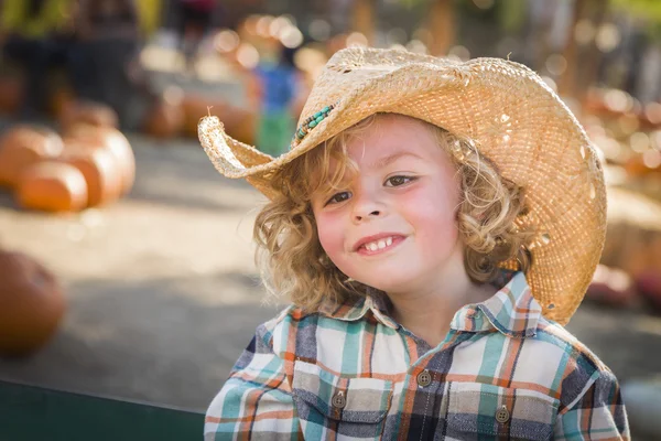 Pequeño niño en sombrero de vaquero en el parche de calabaza —  Fotos de Stock