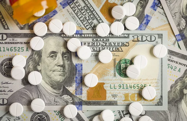 Pílulas de medicina espalhadas no recém-projetado cem dólares bi — Fotografia de Stock