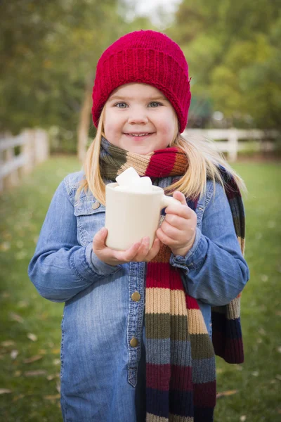 Carino ragazza che tiene tazza di cacao con malva di palude fuori — Foto Stock