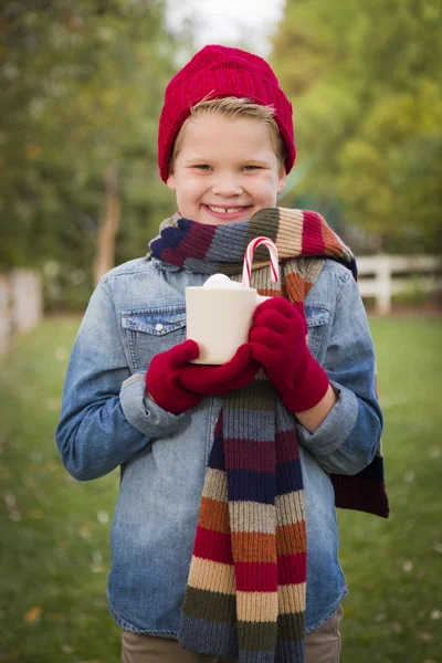 Jeune garçon en vêtements chauds tenant tasse de cacao chaud à l'extérieur — Photo